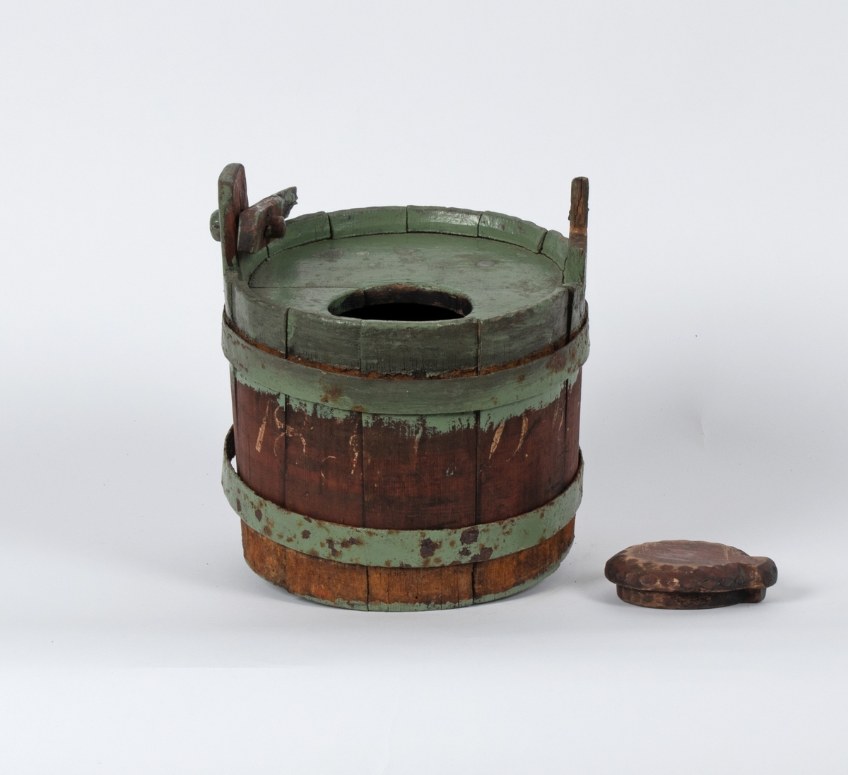 Lagget beholder med lokk og hank. Gjorder av jern. Spuns i helleåpningen i lokket. Hanken er ødelagt.