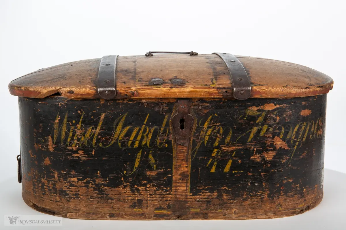 Sveipet bomme med avrundet, hengslet lokk, bærehåndtak av jern, nøkkelhullbeslag og innvendig kistelås. Hengslebeslagen griper om bommens bakside og lokk. Sponendene er sydd sammen med tykke tæger, og bunne er spikret fast.