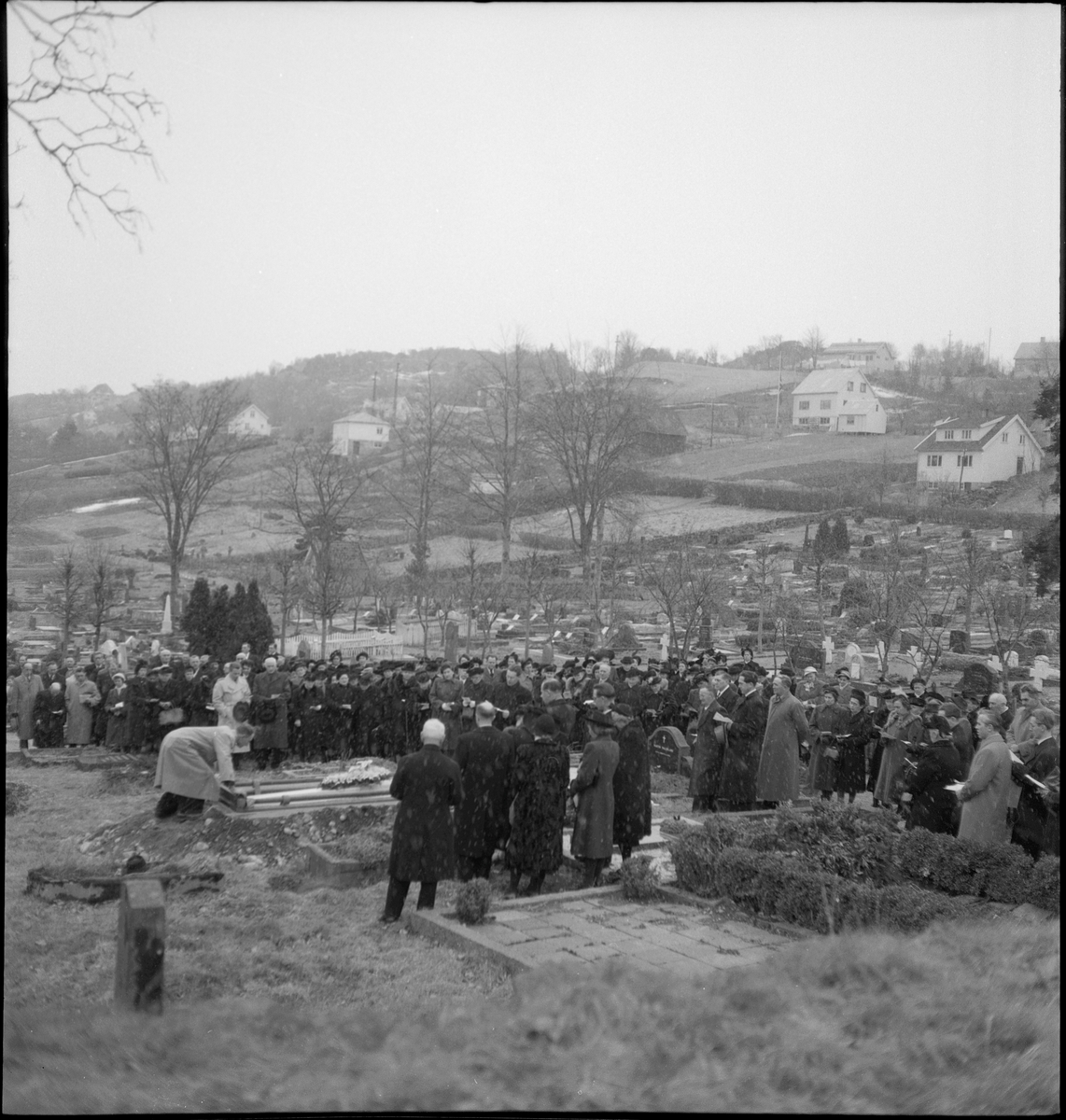 Begravelse i nærheten av Egersund. Det er bilder av kista med blomster, og av seremonien med folk som følger den døde til graven.