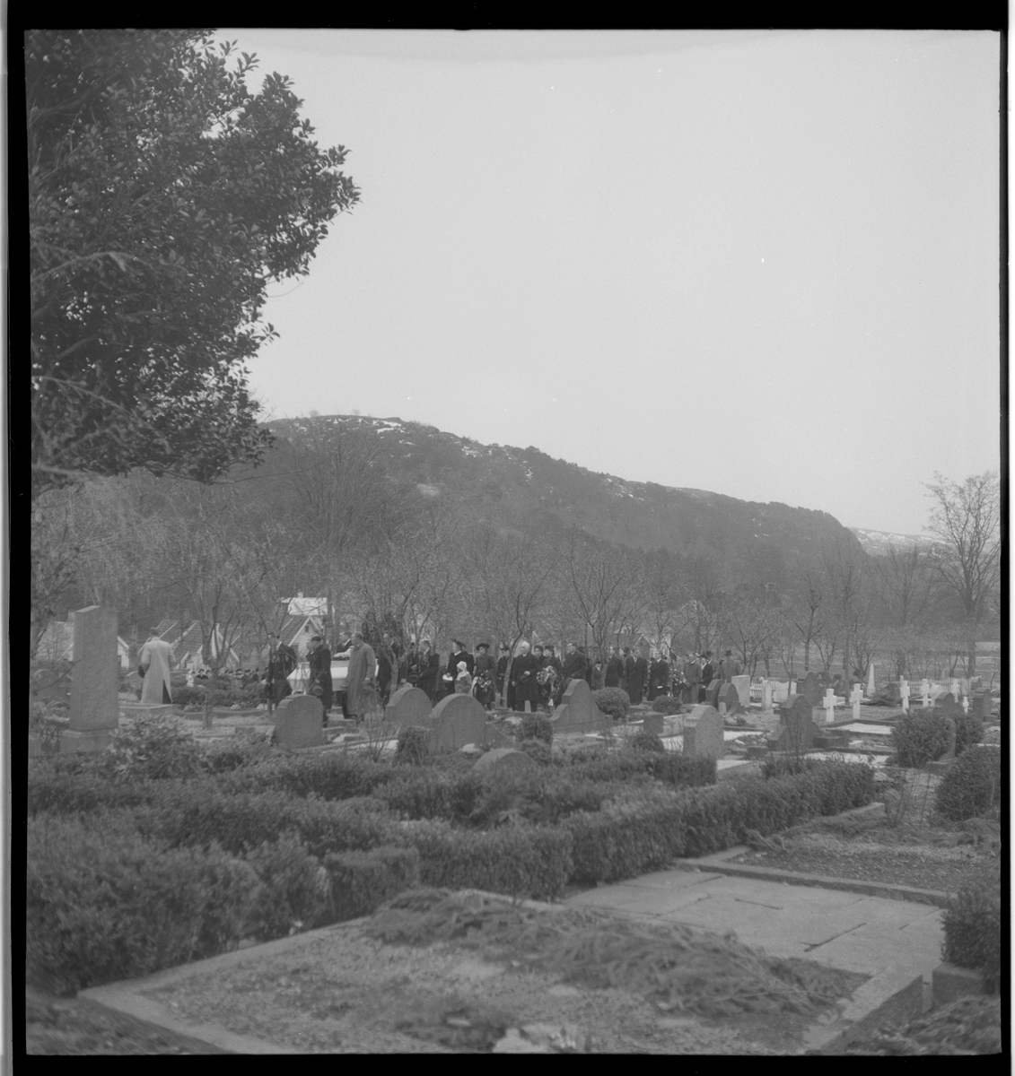 Begravelse i nærheten av Egersund. Det er bilder av kista med blomster, og av seremonien med folk som følger den døde til graven.