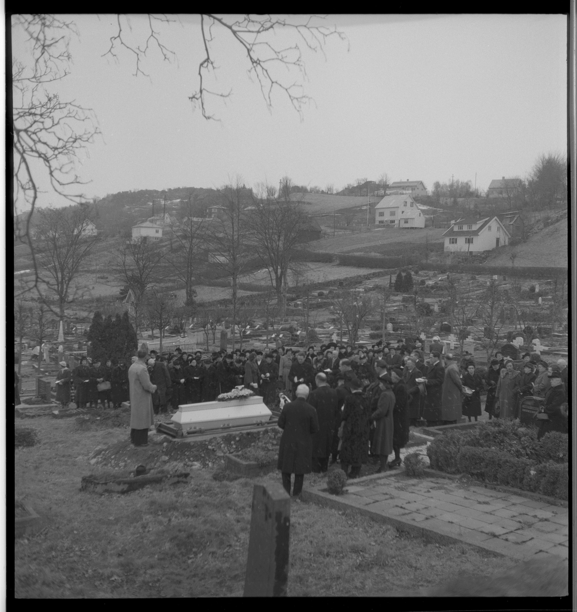 Begravelse i nærheten av Egersund. Det er bilder av kista med blomster, og av seremonien med folk som følger den døde til graven.