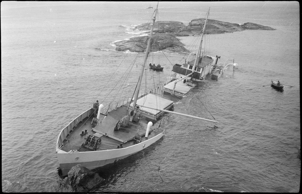 Lasteskipet "Rolfsøy" på grunn utenfor Egersund. Flere mindre båter er uten for å se og forankre skipet.