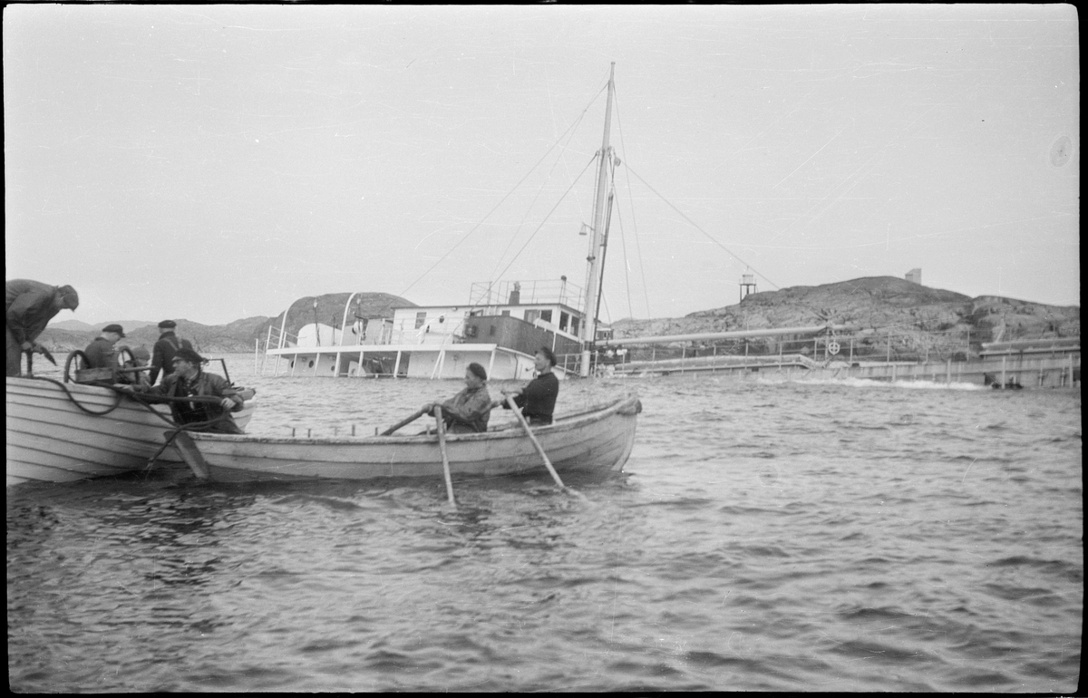 Lasteskipet "Rolfsøy" på grunn utenfor Egersund. Flere mindre båter er uten for å se og forankre skipet.