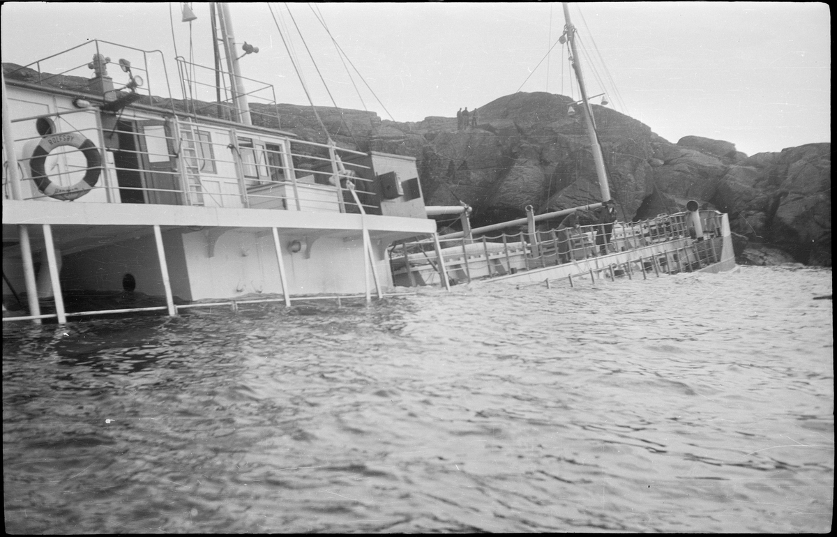 Lasteskipet "Rolfsøy" på grunn utenfor Egersund. Flere mindre båter er uten for å se og forankre skipet.