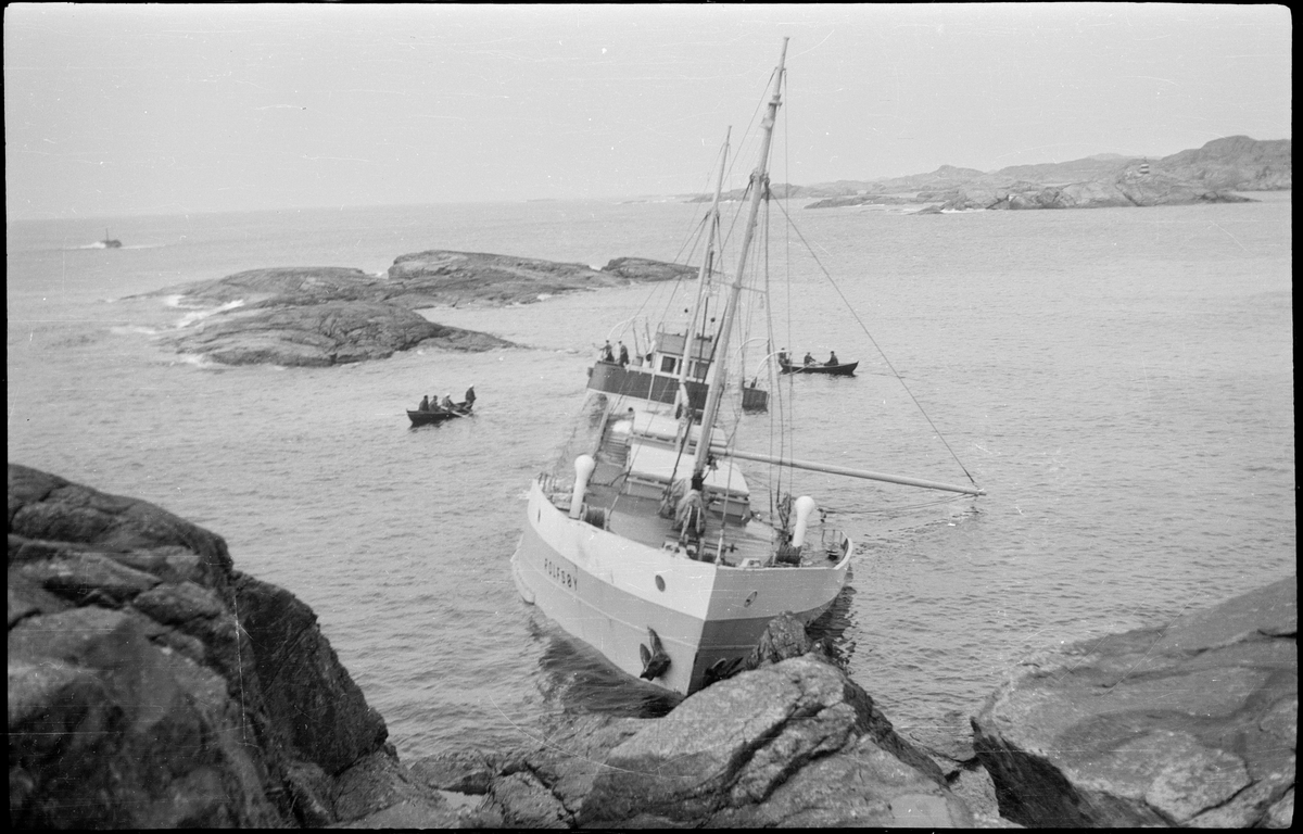 Lasteskipet "Rolfsøy" på grunn utenfor Egersund. Flere mindre båter er uten for å se og forankre skipet.