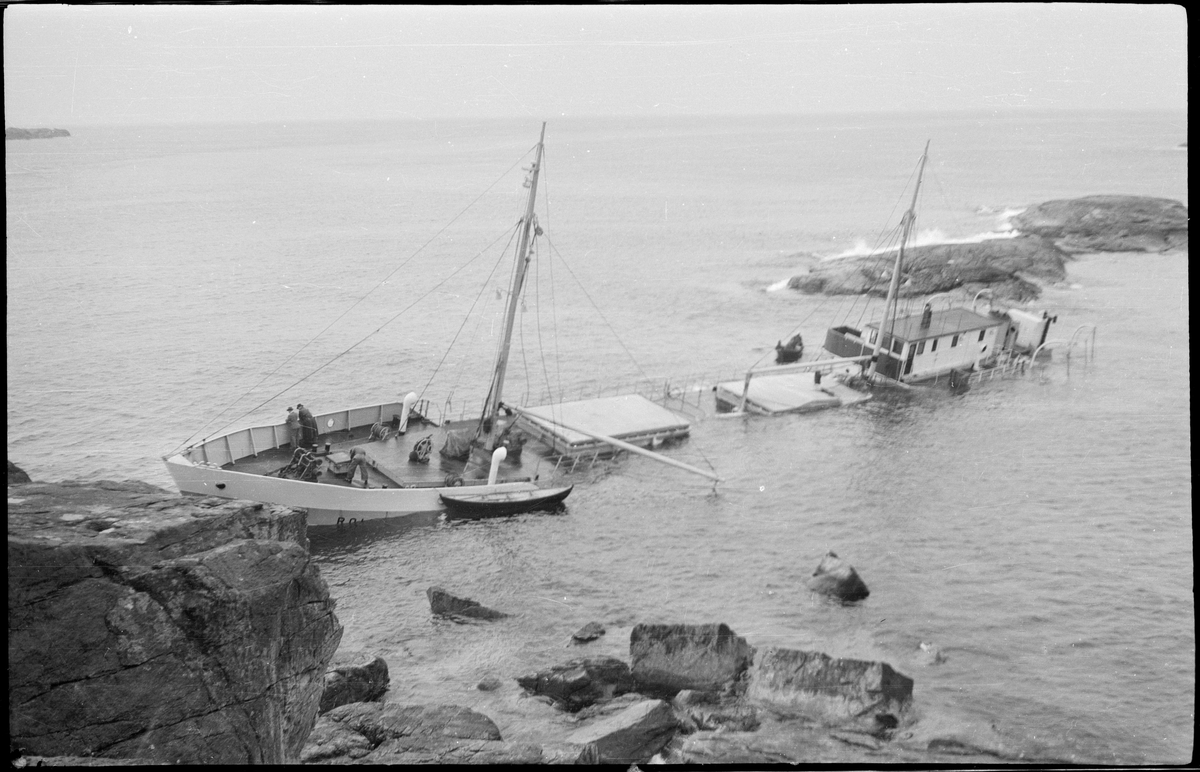 Lasteskipet "Rolfsøy" på grunn utenfor Egersund. Flere mindre båter er uten for å se og forankre skipet.