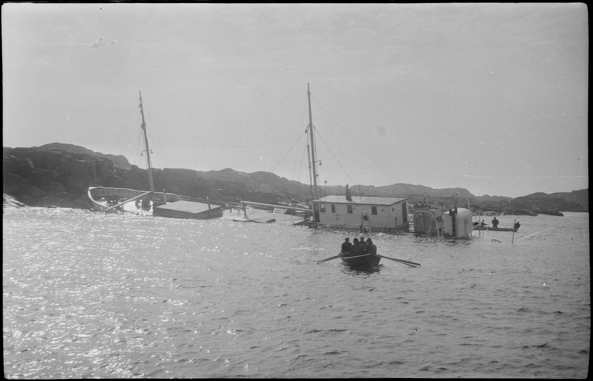 Lasteskipet "Rolfsøy" på grunn utenfor Egersund. Flere mindre båter er uten for å se og forankre skipet.