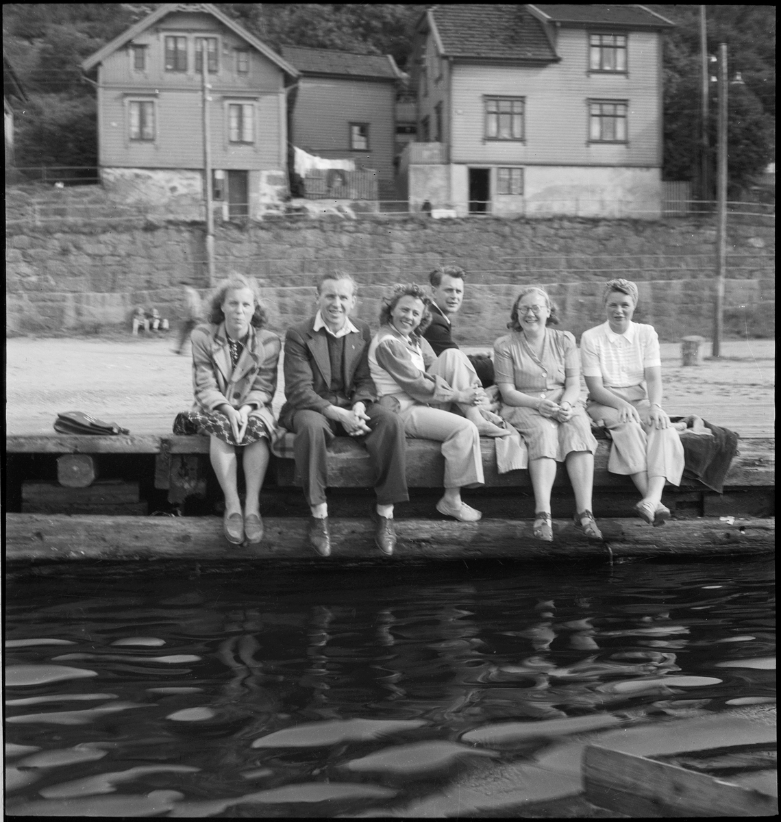 En vennegjeng er samlet for å feire Sankthans i Egersund. De er på båttur og sitter på en brygge vendt mot Lindøya.