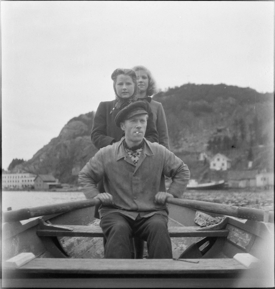 En ung mann og to unge kvinner ror i Vågen i Egersund.