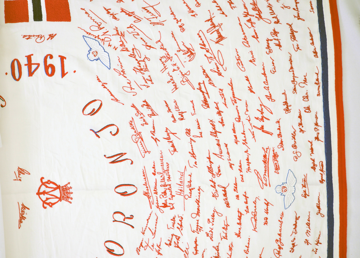 Duk som inneholder navnetrekkene til de norske guttene som ankom Little Norway, Toronto, for å bli flyvere. Duken er håndbrodert av Harriet Skogen som var sekretær til kaptein Omeyer ansvarlig for selektering av flyelevene.
Broderingen startet ved årsskifte 1940/41 og fortsatte til krigens slutt.
Duken ble gitt til Forsvarsmuseet tidlig på 1990 - tallet av kunstnerinnen.