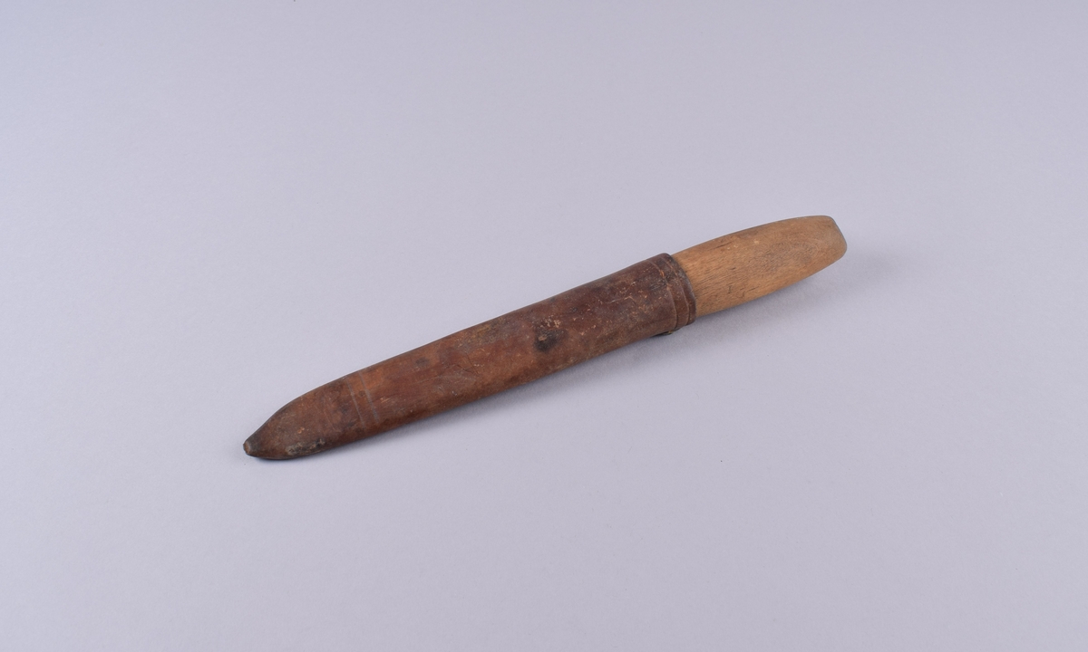 Kniv med skaft av ubehandlet tre og slire i lær.
Stålblad og -holk. Sliren har en bærestropp av sort lær med knapphull.