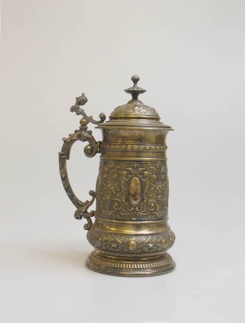 Två fotbollspokaler.
1) Pokal formad som en ölsejdel av förvilvrad mässing med nyrokokodekor. Lock med handtag. Delar av handtaget på sidan av sejdeln och handtaget på locket är av tenn. Text: "Fotboll Landskrona 19 24/4 03". Stämplar undertill: "F.W.Q.L.". Mått: H 27, Diam upptill 10,5, Diam nedtill 12,5 cm.
2) Pokal av förvilvrad mässing med nyrokokodekor. Lock med handtag i form av en pojke. Text: "Fotboll Wäsby 19 14/8 04". Mått: H 42, Diam upptill 12, Diam nedtill 11 cm.