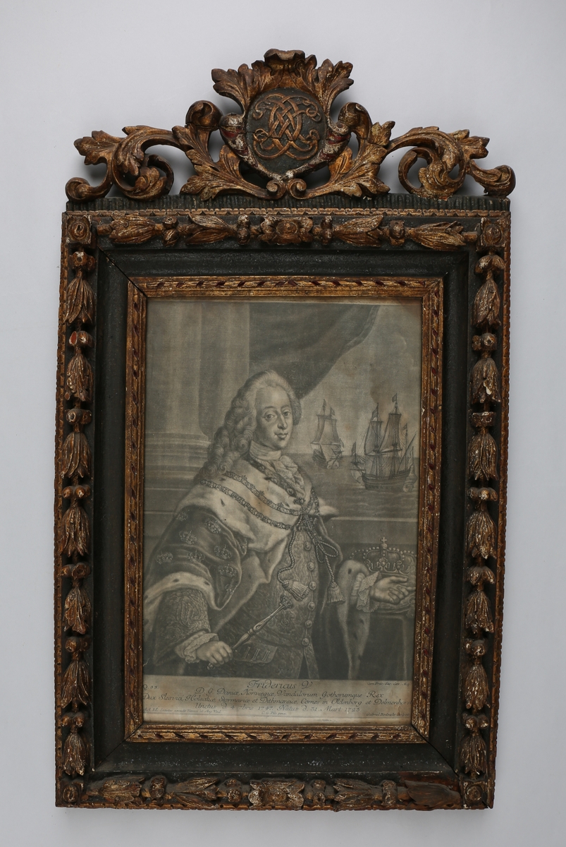 Portrett av Frederik 5, konge av Danmark-Norge 1746-1766. Kongen er avbildet til livet. Han fyller det meste av bildets venstre side og nedre partier. I høyre hånd holder han septer, den venstre peker til siden. Bak venstre hånd ligger en krone på et bord. Kongen har lang parykk og hermelinsbesatt kappe med innvevde kroner og halsduk. Han bærer elefantordenens kjede og kjede med kors og Christian 5's monogram. Bak kongen er det et draperi og på høyre side to skip.