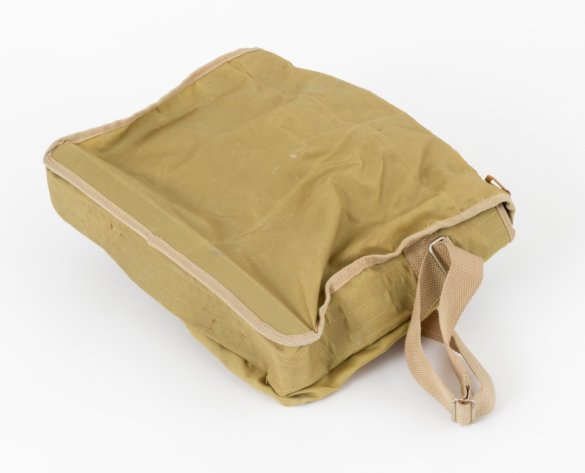 Veske med skulderreim brukt til å oppbevare utstyr under fiske. Veska er ei klaffeveske laget i grønt og brunt nylonstoff med detaljer i lyst kunstklær og metall. Den er kantet med beige bånd, samme farge som skulderreima. Veska består av et stort rom, i tillegg til to lommer, ei ytterlomme og ei lomme på utsiden av klaffen. Veska lukkes med to tykknapper. Lommene lukkes med glidelås.