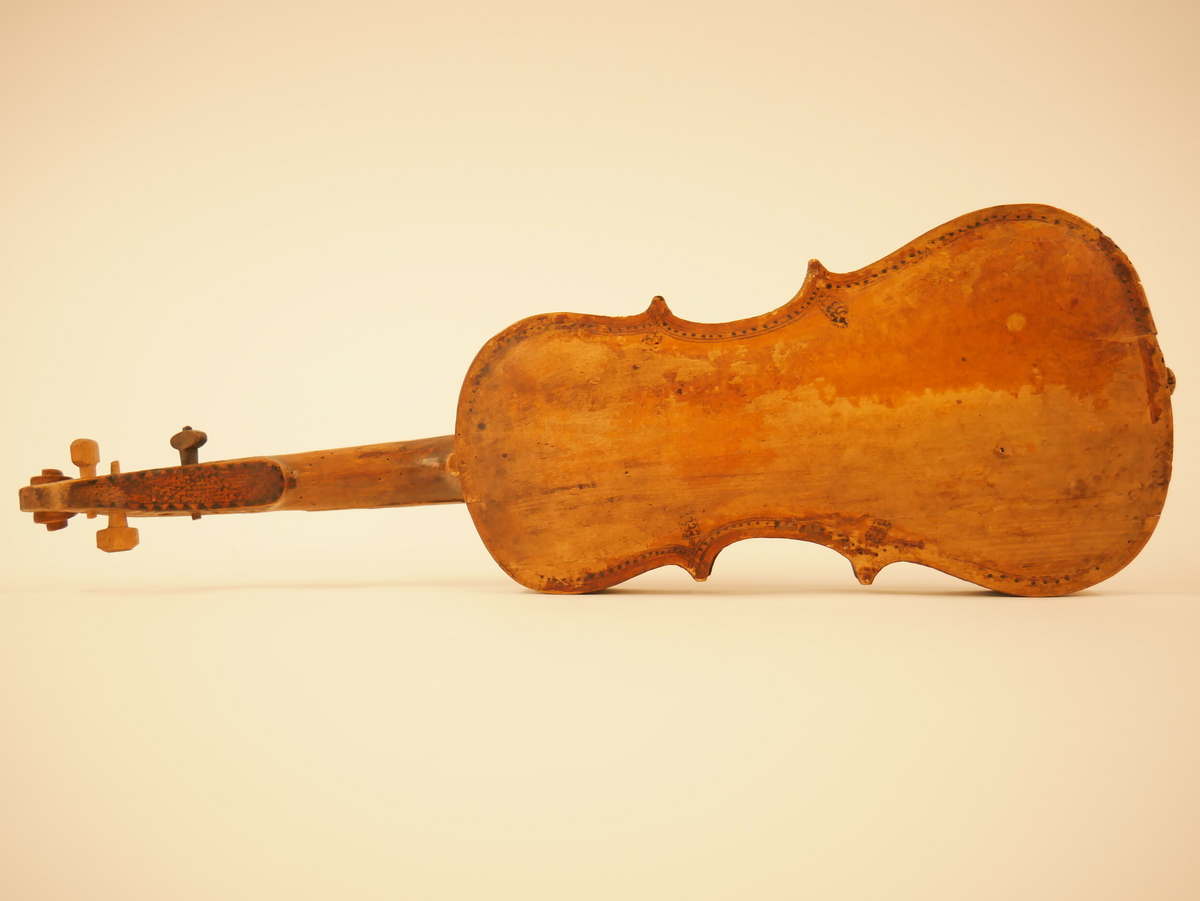 Hardangerfele. Gripebrett med dekor i tre og bein. Rikt dekorert. 
Overflatebehandla med lakk og tusj. Fint avpussa. 
Fela ligg oppi ei felekasse som truleg ikkje høyrar til. 
Lapp med tekst og årstal påskrive limt på innsida av fela.