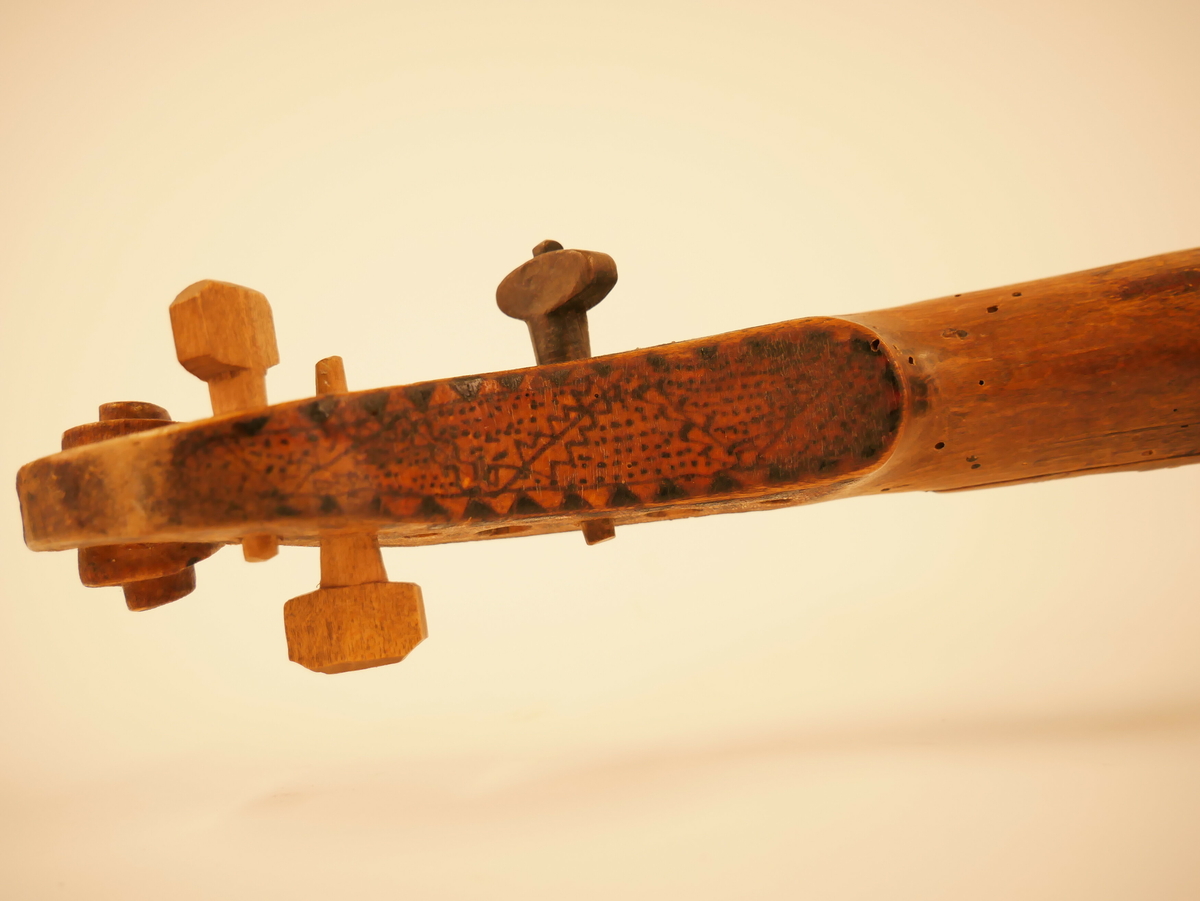 Hardangerfele. Gripebrett med dekor i tre og bein. Rikt dekorert. 
Overflatebehandla med lakk og tusj. Fint avpussa. 
Fela ligg oppi ei felekasse som truleg ikkje høyrar til. 
Lapp med tekst og årstal påskrive limt på innsida av fela.