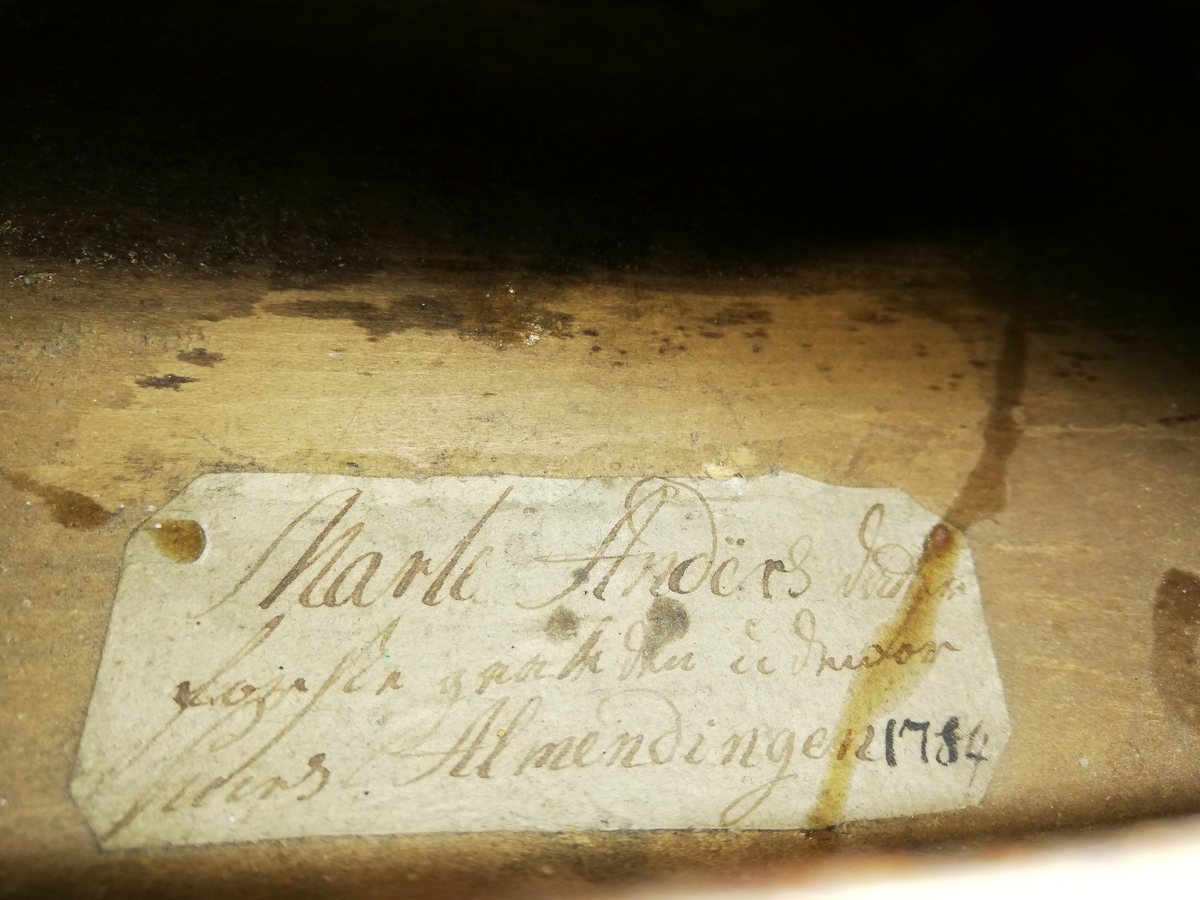 Hardangerfele. Gripebrett med dekor i tre og bein. Rikt dekorert. 
Overflatebehandla med lakk og tusj. Fint avpussa. 
Fela ligg oppi ei felekasse som truleg ikkje høyrar til. 
Lapp med tekst og årstal påskrive limt på innsida av fela.