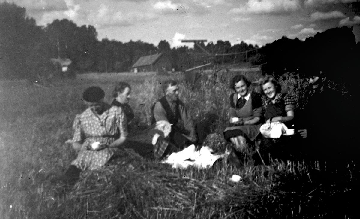 Apelgården på Efraim Magnussons (1876-1960) marker, okänt årtal. 
Från vänster: okänd, okänd, okänd, Lisa Eriksson Jakobsson (1917 - 2006), Heljered samt Inga Magnusson (Efraims dotter) samt okänd.