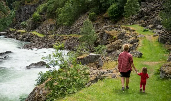 Bilde av kvinne og barn hånd i hånd langs gammel veg.