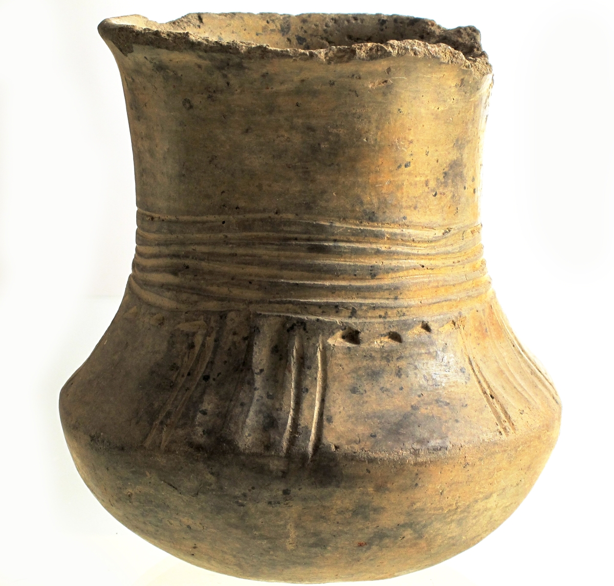 Leirkar av lyst brunlig, forholdsvis tykt, godt brent gods med glattet overflate av form som Bøe: anf. arb. fig. 157, men med noe kortere hals. Orneringen, som begynner midt på denne, består av 4-6 rekker horisontale linjebunter, som er innrisset nokså skjødesløst. Herunder - på skulderen - 4 felt med vertikale hulkiler og linjebunter anbrakt parvis. Mellom disse finnes glatte partier i hvis øvre kant det løper en punktrekke. Buken uornert, bunnen oppdrevet og avgrenset med en punktrekke. Noen skall mangler langs randen, eller utmerket bevart. Høyde 10,7 cm, munningsdiam. 8 cm, bukvidde 10,1 cm. (A. 321.) 

