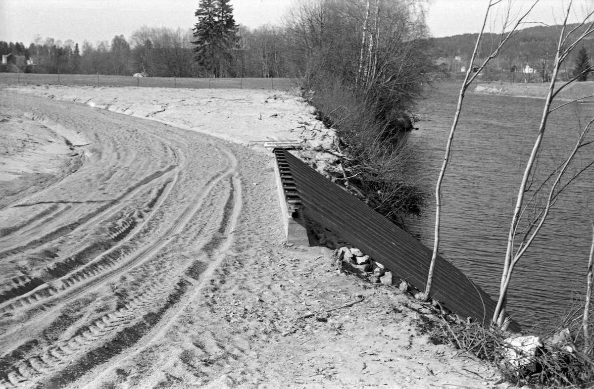 Utislagsrampe ved Galterud i Sør-Odal i Hedmark, bygd i 1959-1960. Fotografiet er tatt fra en veg som svinger ned mot elvebredden, der det var støpt en betongmur. Mellom krona på denne muren og elva var det bygd ei rampe av parallelle jernbaneskinner, der tømmer som ble veltet av lastebilene kunne skli ned i elva.