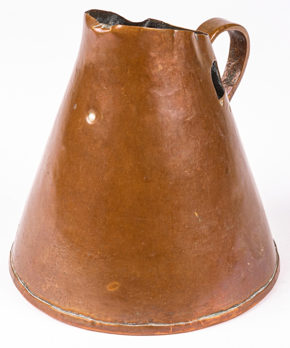 Brännvinsmått av koppar, konisk form, ett handtag. En bit bortklippt invid kröningen. Krönt 1808, LCK.