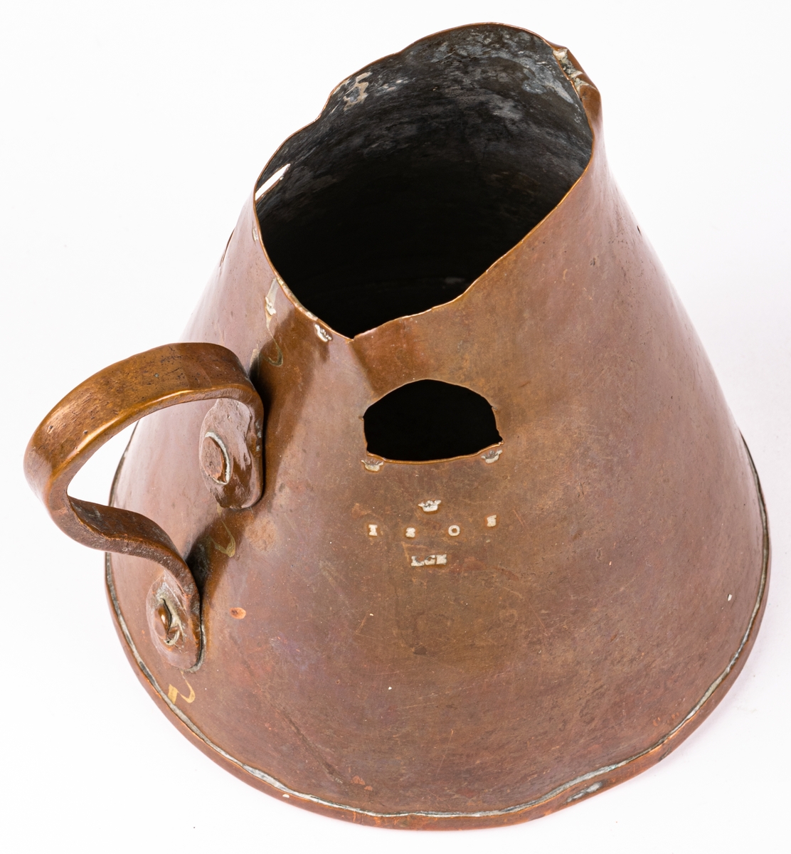 Brännvinsmått av koppar, konisk form, ett handtag. En bit bortklippt invid kröningen. Krönt 1808, LCK.