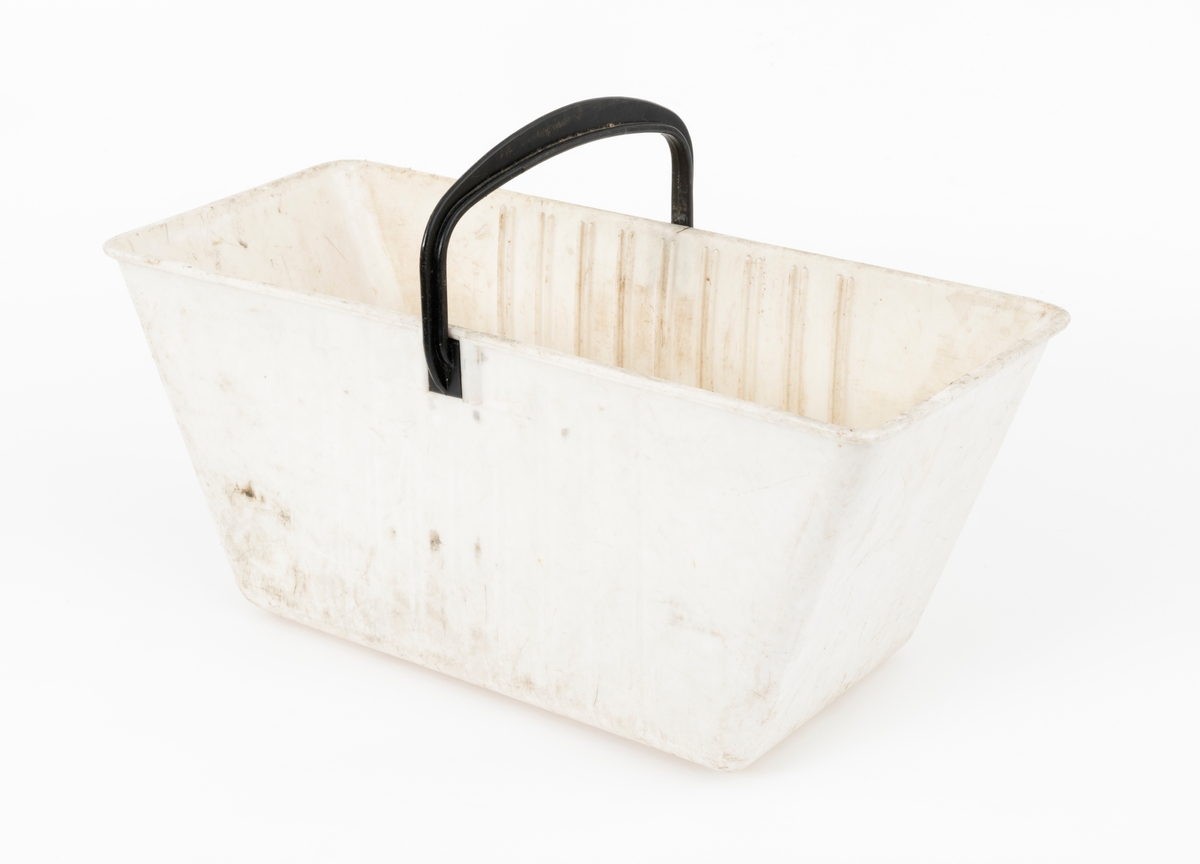 Plantekasse for barrotplanter til plantefelt i skogen.  Plantekassa er lagd av plast. Sjølve beholderen er kvit. Sett ovenfra er formen rektangulær, riktignok med lett avrundete hjørner. Standflata er 32 centimeter lang og 17 centimeter bred.  I overkant er det 47,6 centimeter mellom ytterendene i lengderetningen og 19,9 centimeter i bredderetningen. Høyden på sjølve plantekassa er 20 centimeter. På undersida (kassebotnen) er det fire plastribber, som er plassert vinkerlrett på plantekassas lengdeakse. I overkant er det påsatt en bærehank, lagd av svart plast.  Festepunktene er noenlunde sentrerte i forhold til kassas lengderetning, og sammenføyinga er løst ved at handtaksendene er gradet inn mellom ribber øverst på kassas yttersider. Inne i plantekassa er det 9 vertikale ribbepar, plassert med cirka 2,3 centimeters innbyrdes senteravstand på langsidene. Mellom disse ribbene kunne det stikkes inn ei kvit plastplate med skrådd overkant, der der var pålimt en noenlunde rektangulær klut som skulle fuktes og brukes som dekke over planterøttene. Her er ikke denne skilleplata med dekklut intakt. Årsaken til at plantekassene ble delt i to ved hjelp av slike flyttbare komponenter var at den ene delen av plantekassa skulle inneholde et begrenset antall barrotplanter, den andre skulle romme «fylljord». Dette var masse plantøren supplerte med der det var steinete mark, slik at det var lite humus å plassere planterøttene i. Fylljorda sikret samtidig en viss næringstilgang til plantene og bidro til å holde på fuktighet, noe som var viktig for at plantene skulle overleve den vanskelige startfasen på kulturfeltene. Kluten ble fuktet når kassa var i bruk for den skulle hindre tørkeskader på de sårbare røttene på barrotplantene.