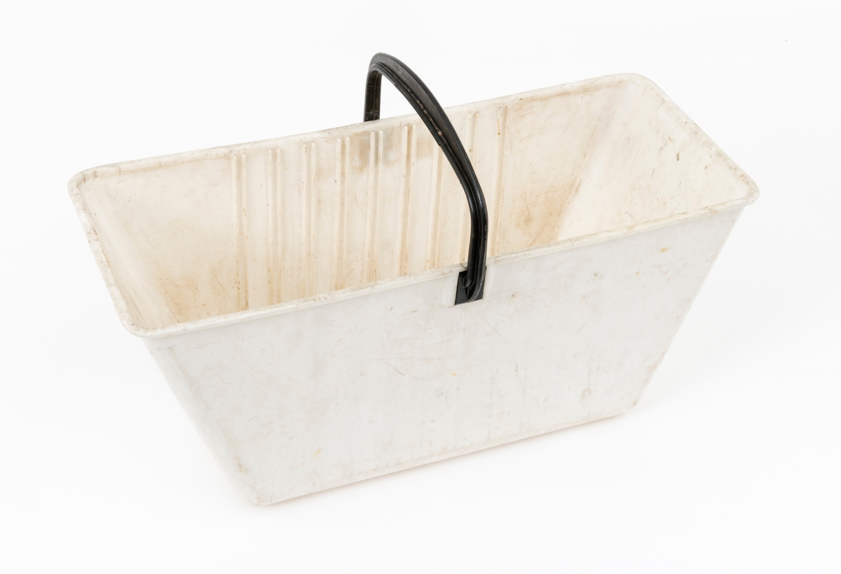Plantekasse for barrotplanter til plantefelt i skogen.  Plantekassa er lagd av plast. Sjølve beholderen er kvit. Sett ovenfra er formen rektangulær, riktignok med lett avrundete hjørner. Standflata er 32 centimeter lang og 17 centimeter bred.  I overkant er det 47,6 centimeter mellom ytterendene i lengderetningen og 19,9 centimeter i bredderetningen. Høyden på sjølve plantekassa er 20 centimeter. På undersida (kassebotnen) er det fire plastribber, som er plassert vinkerlrett på plantekassas lengdeakse. I overkant er det påsatt en bærehank, lagd av svart plast.  Festepunktene er noenlunde sentrerte i forhold til kassas lengderetning, og sammenføyinga er løst ved at handtaksendene er gradet inn mellom ribber øverst på kassas yttersider. Inne i plantekassa er det 9 vertikale ribbepar, plassert med cirka 2,3 centimeters innbyrdes senteravstand på langsidene. Mellom disse ribbene kunne det stikkes inn ei kvit plastplate med skrådd overkant, der der var pålimt en noenlunde rektangulær klut som skulle fuktes og brukes som dekke over planterøttene. Her er ikke denne skilleplata med dekklut intakt. Årsaken til at plantekassene ble delt i to ved hjelp av slike flyttbare komponenter var at den ene delen av plantekassa skulle inneholde et begrenset antall barrotplanter, den andre skulle romme «fylljord». Dette var masse plantøren supplerte med der det var steinete mark, slik at det var lite humus å plassere planterøttene i. Fylljorda sikret samtidig en viss næringstilgang til plantene og bidro til å holde på fuktighet, noe som var viktig for at plantene skulle overleve den vanskelige startfasen på kulturfeltene. Kluten ble fuktet når kassa var i bruk for den skulle hindre tørkeskader på de sårbare røttene på barrotplantene.