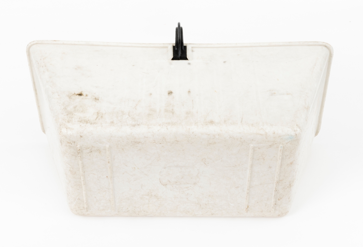 Plantekasse for barrotplanter til plantefelt i skogen.  Plantekassa er lagd av plast. Sjølve beholderen er kvit. Sett ovenfra er formen rektangulær, riktignok med lett avrundete hjørner. Standflata er 32 centimeter lang og 17 centimeter bred.  I overkant er det 47,6 centimeter mellom ytterendene i lengderetningen og 19,9 centimeter i bredderetningen. Høyden på sjølve plantekassa er 20 centimeter. På undersida (kassebotnen) er det fire plastribber, som er plassert vinkerlrett på plantekassas lengdeakse. I overkant er det påsatt en bærehank, lagd av svart plast.  Festepunktene er noenlunde sentrerte i forhold til kassas lengderetning, og sammenføyinga er løst ved at handtaksendene er gradet inn mellom ribber øverst på kassas yttersider. Inne i plantekassa er det 9 vertikale ribbepar, plassert med cirka 2,3 centimeters innbyrdes senteravstand på langsidene. Mellom disse ribbene kunne det stikkes inn ei kvit plastplate med skrådd overkant, der der var pålimt en noenlunde rektangulær klut som skulle fuktes og brukes som dekke over planterøttene. Her er ikke denne skilleplata med dekklut intakt. Årsaken til at plantekassene ble delt i to ved hjelp av slike flyttbare komponenter var at den ene delen av plantekassa skulle inneholde et begrenset antall barrotplanter, den andre skulle romme «fylljord». Dette var masse plantøren supplerte med der det var steinete mark, slik at det var lite humus å plassere planterøttene i. Fylljorda sikret samtidig en viss næringstilgang til plantene og bidro til å holde på fuktighet, noe som var viktig for at plantene skulle overleve den vanskelige startfasen på kulturfeltene. Kluten ble fuktet når kassa var i bruk for den skulle hindre tørkeskader på de sårbare røttene på barrotplantene.