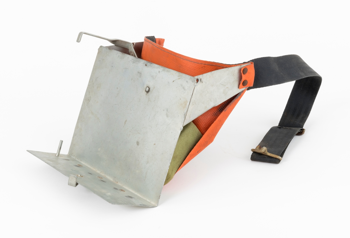 Hoftebelte med festebrakett for pottebrett med pluggrotplanter som skulle brukes til å etablere nye skogbestand. Pottebrettene ble festet vertikalt, på ei vinklert lettmetallplate som er 25 centimeter bred og snaut 20 centimeter høy. "Hylla" nederst på denne plata er 8,2 centimeter bred. For å få et standard pottebrett, som måler 40 X 30 centimeter, til å sitte fast på denne braketten, er det montert bøyler med vinklete endeledd, både på undersida av "hylla" og på baksida av den noe større plata. Den sistnevnte er fjærbelastet. Ytterst på overkantene av den store plata er det påsveiset litt skråstilte, om lag 15 centimeter lange stag, også de av samme type metallplate. I ytterendene av disse stagene er det festet et oransjefarget, gummiert lerretsstykke som delvis omslutter en lysegrønn skumgummitbit. Lerretet skulle ligge an mot hofa til brukeren, og skumgummibiten skulle tjene som pute og hindre gnag. I den øvre enden av lerretsbiten er det påsydd og fastnaglet et 4,7 centimeter bredt tettvevd belte av svartfarget syntetisk materiale. Dette beltet skal føres rundt plantørens hofter og festes med et endebeslag i en krok i det ene staget på braketten. Lengden på beltet er justerbar, slik at hoftebeltet kunne brukes av skogkulturaktører med ulik livvidde.