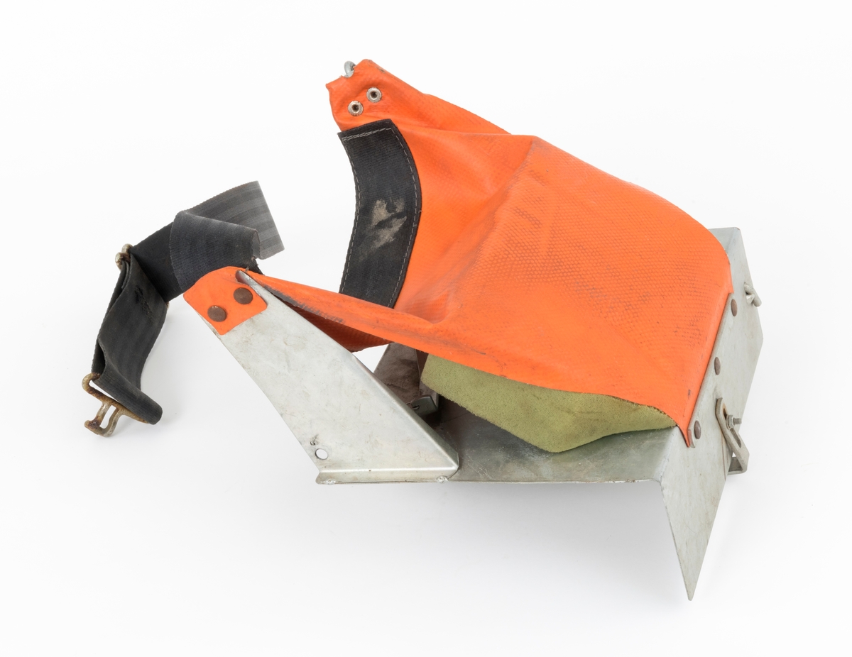 Hoftebelte med festebrakett for pottebrett med pluggrotplanter som skulle brukes til å etablere nye skogbestand. Pottebrettene ble festet vertikalt, på ei vinklert lettmetallplate som er 25 centimeter bred og snaut 20 centimeter høy. "Hylla" nederst på denne plata er 8,2 centimeter bred. For å få et standard pottebrett, som måler 40 X 30 centimeter, til å sitte fast på denne braketten, er det montert bøyler med vinklete endeledd, både på undersida av "hylla" og på baksida av den noe større plata. Den sistnevnte er fjærbelastet. Ytterst på overkantene av den store plata er det påsveiset litt skråstilte, om lag 15 centimeter lange stag, også de av samme type metallplate. I ytterendene av disse stagene er det festet et oransjefarget, gummiert lerretsstykke som delvis omslutter en lysegrønn skumgummitbit. Lerretet skulle ligge an mot hofa til brukeren, og skumgummibiten skulle tjene som pute og hindre gnag. I den øvre enden av lerretsbiten er det påsydd og fastnaglet et 4,7 centimeter bredt tettvevd belte av svartfarget syntetisk materiale. Dette beltet skal føres rundt plantørens hofter og festes med et endebeslag i en krok i det ene staget på braketten. Lengden på beltet er justerbar, slik at hoftebeltet kunne brukes av skogkulturaktører med ulik livvidde.
