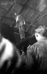 Charles Lindbergh står på vingen till sitt flygplan Lockheed 8 Sirius 'Tingmissartoq' inne i en hangar vid besök på F 2 Karlskrona flygstation på Stumholmen i september 1933.