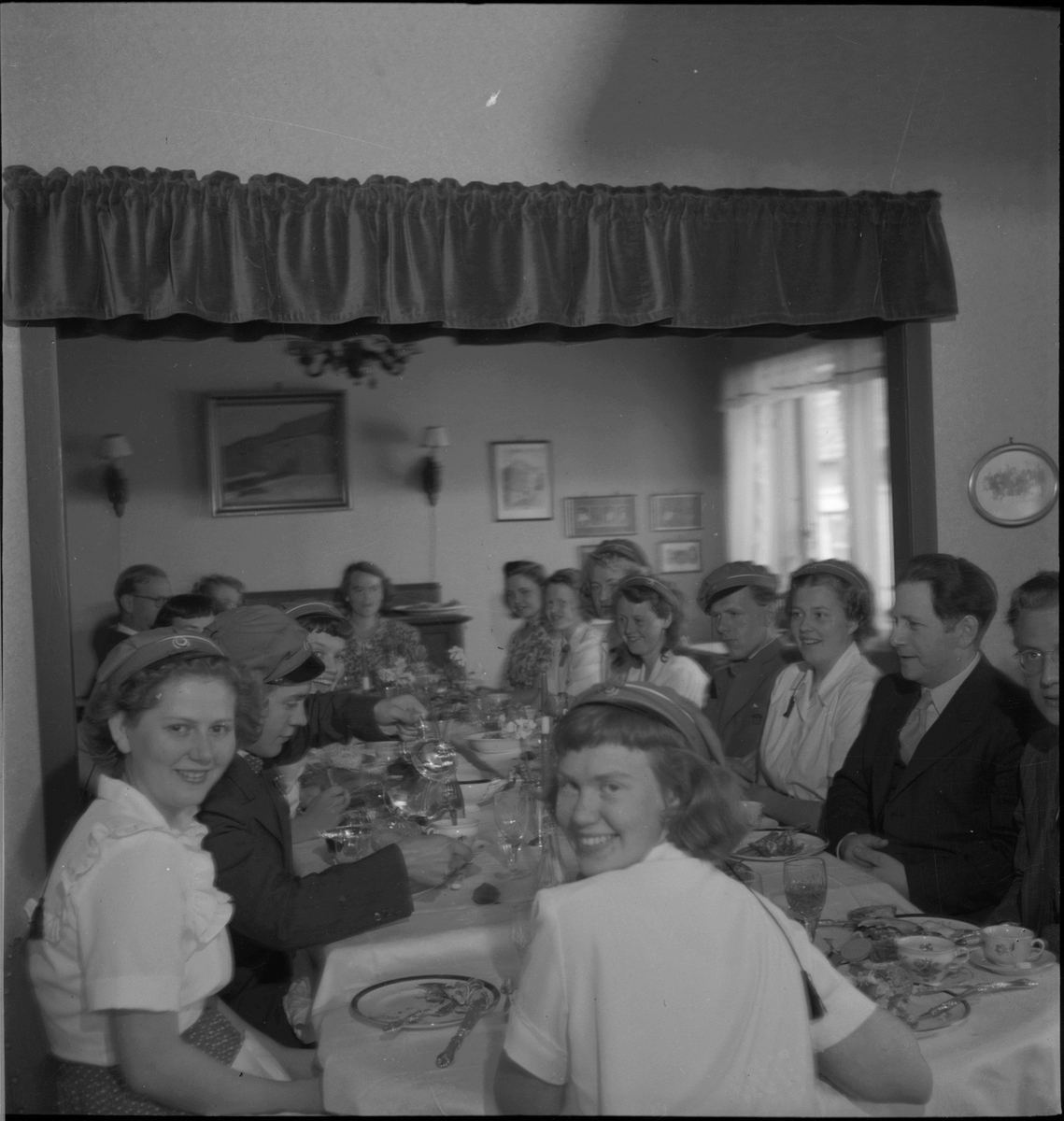 Middagsselskap på 17. mai. Flere av gjestene har russelue.