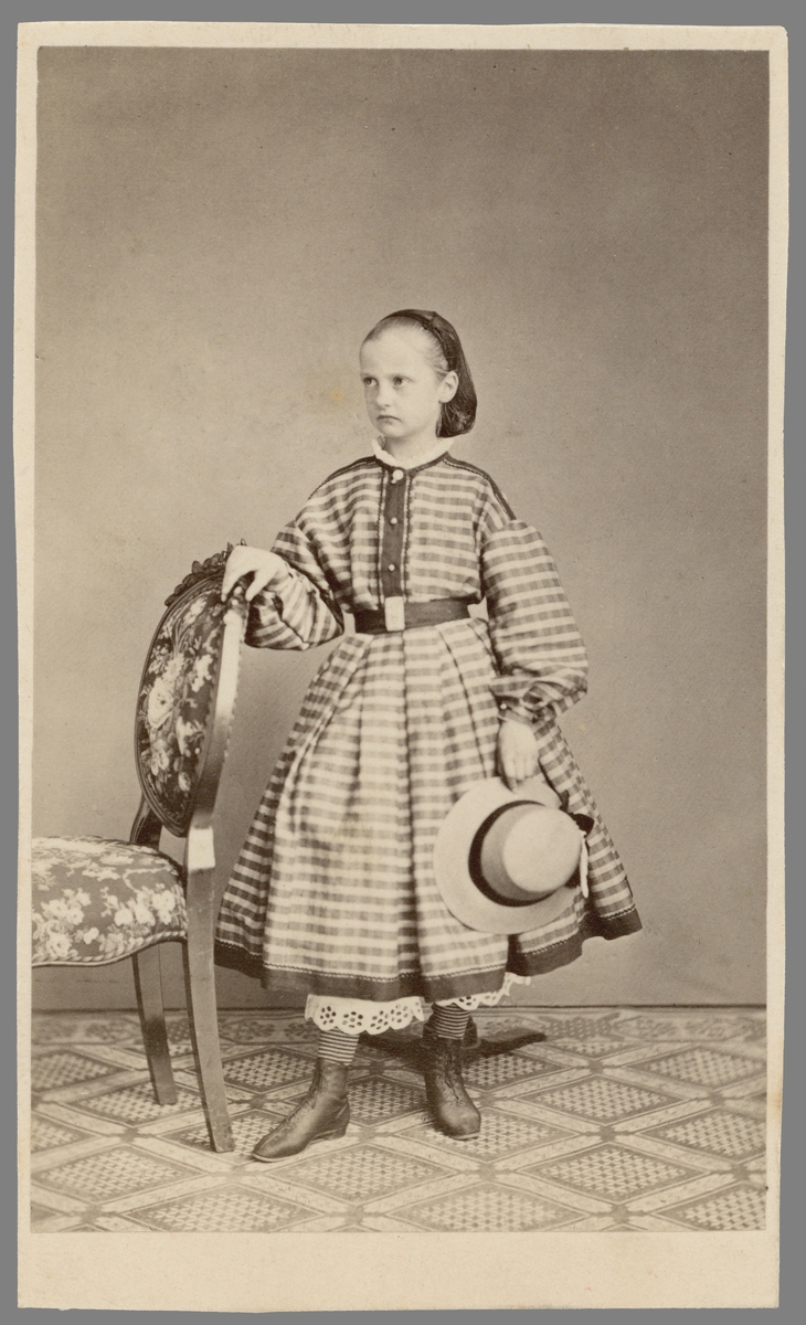 Porträtt av flickan Ellen Fries. Enligt påskrift född 1855 och därmed tolkat vara barndomsbild av Sveriges första kvinnliga filosofie doktor i historia.
Fotografiet är sänt till författaren Carl Anton Wetterbergh, mest känd under pseudonymen Onkel Adam. Skälet till försändelsen har rimligtvis varit Wetterberghs utgivning av Sveriges första barntidning Linnea under åren 1862-72.