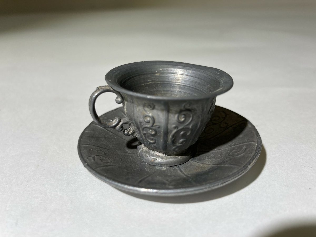 Kaffekopp og -skål til dokkeservise. Dokkeservise ble gitt til jenter til lek som forberedelse til voksenlivet. 