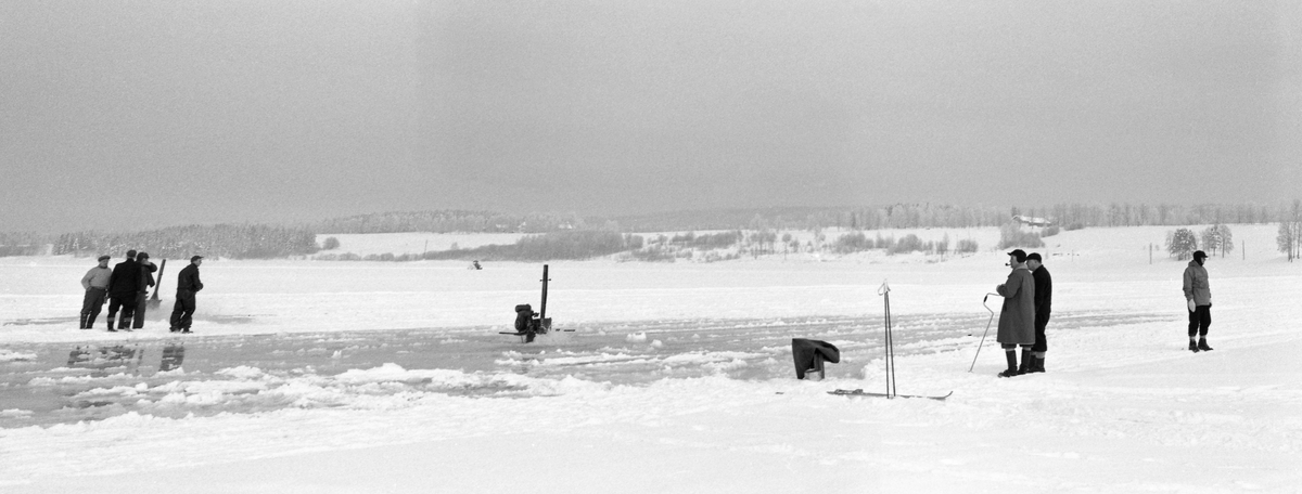 Forberedelser til tømmertillegging på Vingersjøen vinteren 1959. denne vinteren var isen forholdsvis tynn, og den hadde derfor ikke ønskelig bæreevne. Under slike forhold var det vanlig å tråkke eller valse snølaget med sikte på å komprimere snøen slik at kulda i lufta skulle trenge lettere ned i isen. Her testet man en alternativ løsning. Det ble boret hull i isen. Fra disse hullene ble det pumpet vann opp på isflata, der det skulle fryse, slik at islaget ble tjukkere og dermed fikk bedre bæreevne ved tømmertillegginga utover seinvinteren. Arbeidet ble utført ved hjelp av to motordrevne «Tyfon-bor» som ble innleid fra Sverige. Borene var ikke tyngre enn at to menn kunne flytte dem rundt på isflata. Når de brøt gjennom isen fikk de fortsette å gå mens ribbene på boret løftet vann opp på isflata. De borene som ble brukt på Vingersjøen i 1959 ble betjent av Ragnar Nystrøm og Ivan Magnusson fra det norsksvenske skogfirmaet Lier, Varald & Bogen. Målet var å etablere ei isflate på til sammen cirka 160 dekar. På grunn av istjukkelsen var det et generelt forbud mot tømmertillegging på is i denne regionen før 1. februar.