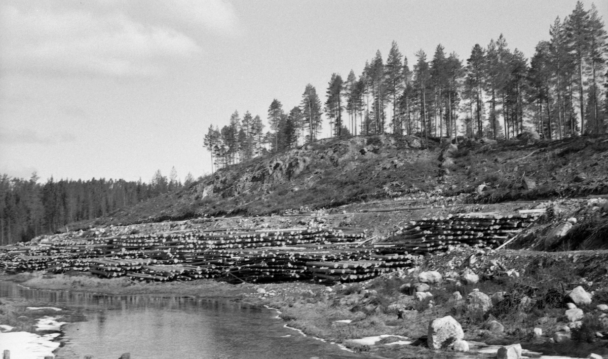 Velteplass for fløtingsvirke ved elva Fallåa i Malungsvassdraget i Romedal allmenning, like ovenfor Rennedammen. Fotografiet ble tatt våren 1960, da denne velteplassen nylig var opparbeidet. Velteplassen befant seg mellom elva og en skogsbilveg, som sannsynligvis var nybygd, og som åpnet muligheter for å kjøre tømmeret ned hit, hvor det var en dam og tømmerrenne som endte i innsjøen Malungen. På velteplassen lå det tømmer i strøvelter. Strøveltene besto av tømmerstokker som lå parallelt i floer, med lengderetningen parallelt med elvas fallretning, vinkelrett på mellomliggende strøstokker. Poenget med denne tilleggingsmåten var at stokkene skulle få en forsiktig tørk før vannføringa ble stor nok til å fløtinga kunne starte og tømmeret kunne rulles ut i elveløpet. Dette reduserte faren for at stokkene ble til søkketømmer på sin lange veg nedover vassdraget. Ble det levert mye tømmer til en velteplass med knapt areal, måtte strøveltene stables forholdsvis høye.