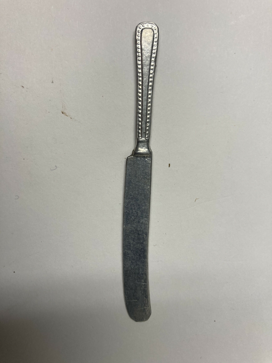 Kniv til bestikk i ni deler til dokkestell. Dokkestell ble gitt til jenter til lek som forberedelse til voksenlivet. 