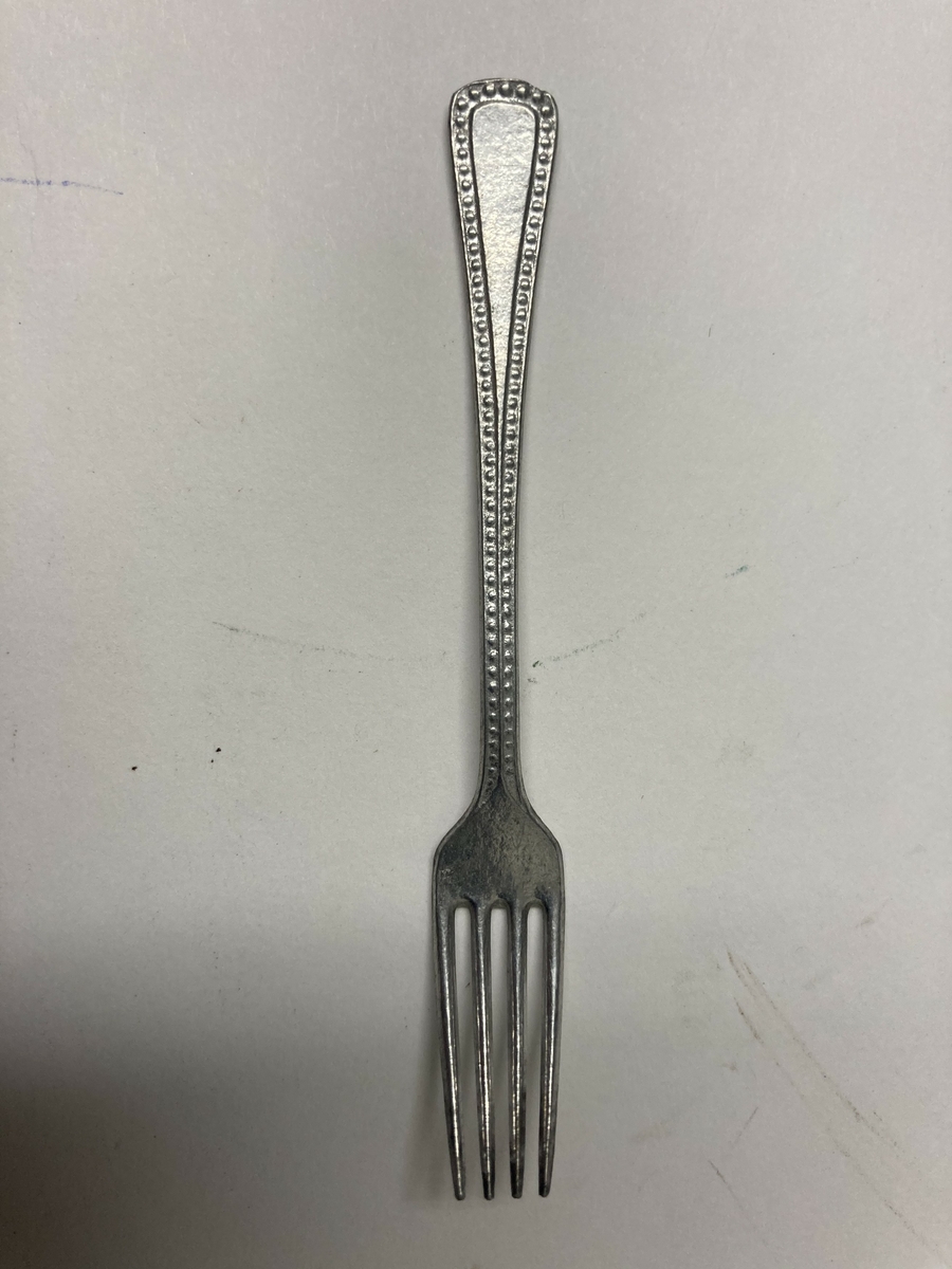 Gaffel til bestikk i ni deler til dokkestell. Dokkestell ble gitt til jenter til lek som forberedelse til voksenlivet. 
