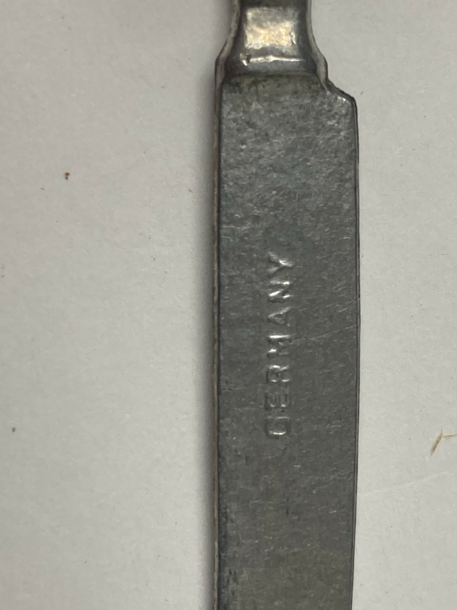 Kniv til bestikk i ni deler til dokkestell. Kniven har en skade. Dokkestell ble gitt til jenter til lek som forberedelse til voksenlivet. 