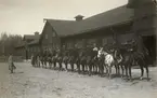 Soldater och häst framför en byggnad.