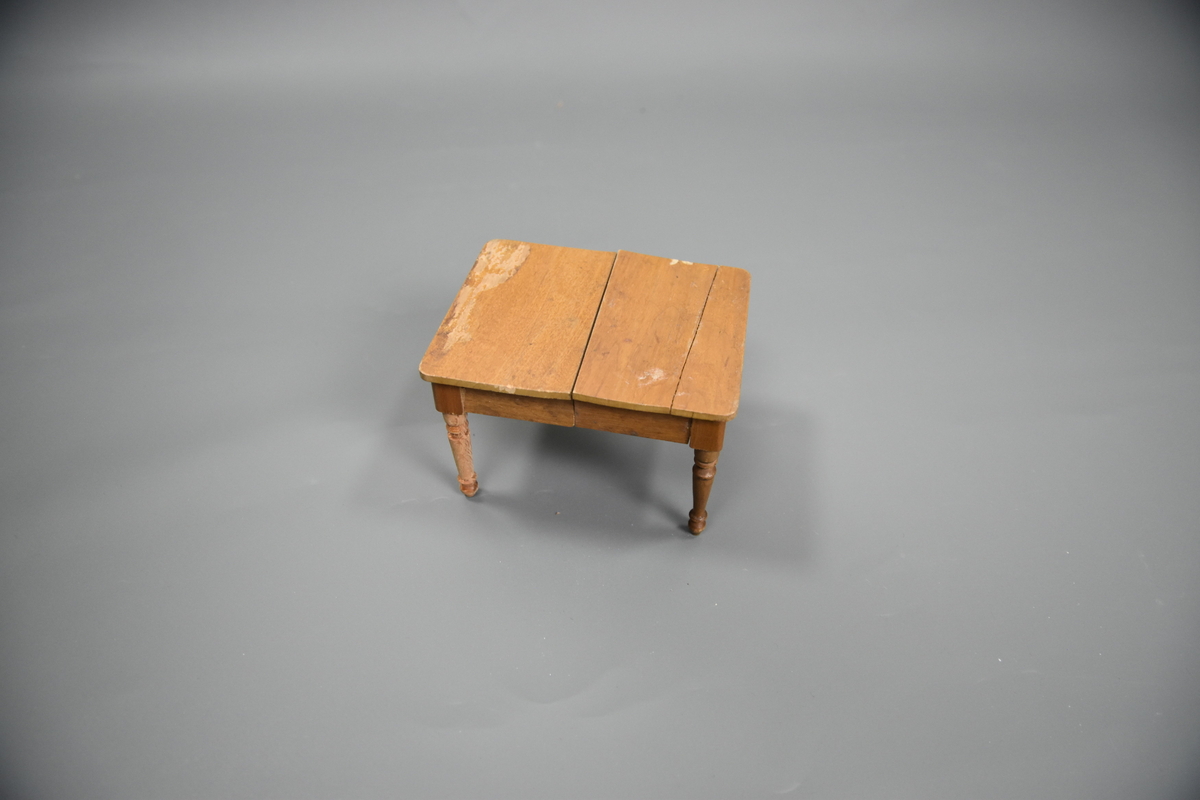 Uttrekkbart spisestuebord til dokkestell. Dokkestell ble gitt til jenter til lek som forberedelse til voksenlivet. 