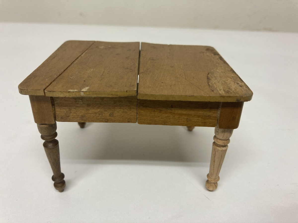 Uttrekkbart spisestuebord til dokkestell. Dokkestell ble gitt til jenter til lek som forberedelse til voksenlivet. 