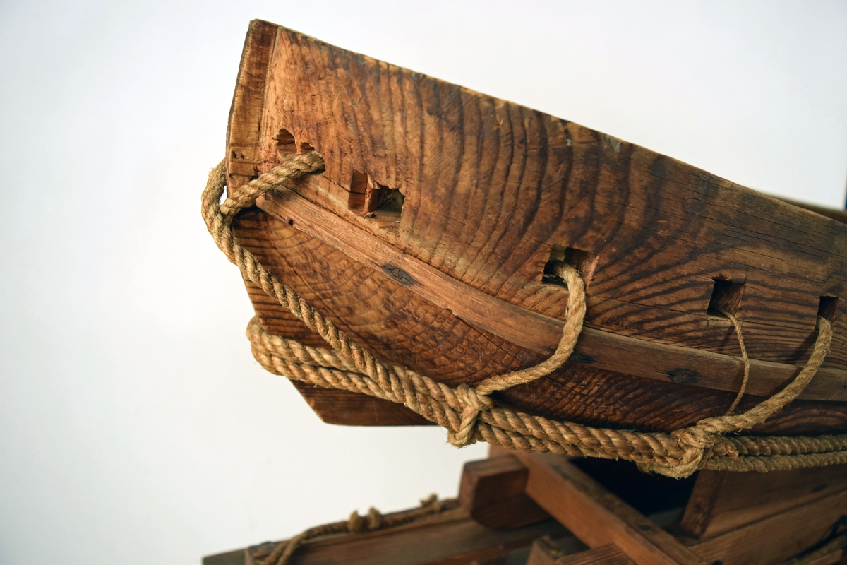 Modell av ett fartyg stående på en upphalningssläde som i sin tur står på en slip. Fartyget består av ett grovt utformat skrov uthugget ur ett trästycke, med kanonportar.
Upphalningssläden, som också är grovt utformad, passar inte till skrovet. Både skrov och släde är försett med olika former av linor och trossar för att användas vid upphalning på en slip. Modellen är omålad.

Löa (mm): 970Modellens dimensioner (mm):  L 955  B 290   H 340