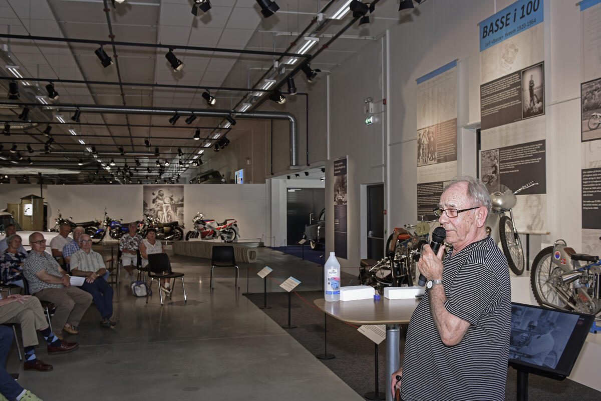 Mann holder tale under åpning av utstillingen Basse i 100.
