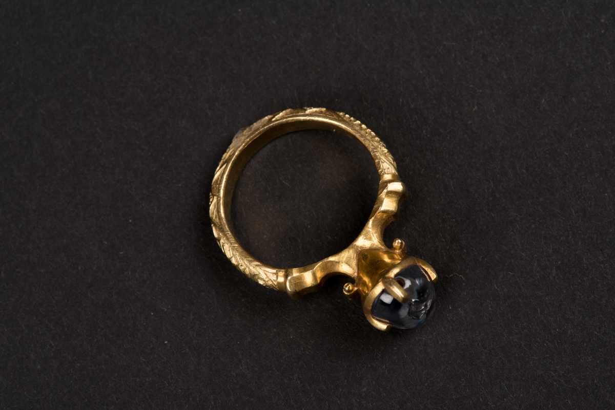 Ring av guld med oval safir.
Safiren vilar i konisk fattning med fyra gripklor. Ursprungligen var troligen ringen belagd med emalj. Ringens utsida har bokstavsfält med betydelsen "safiren vakar över Eder".
