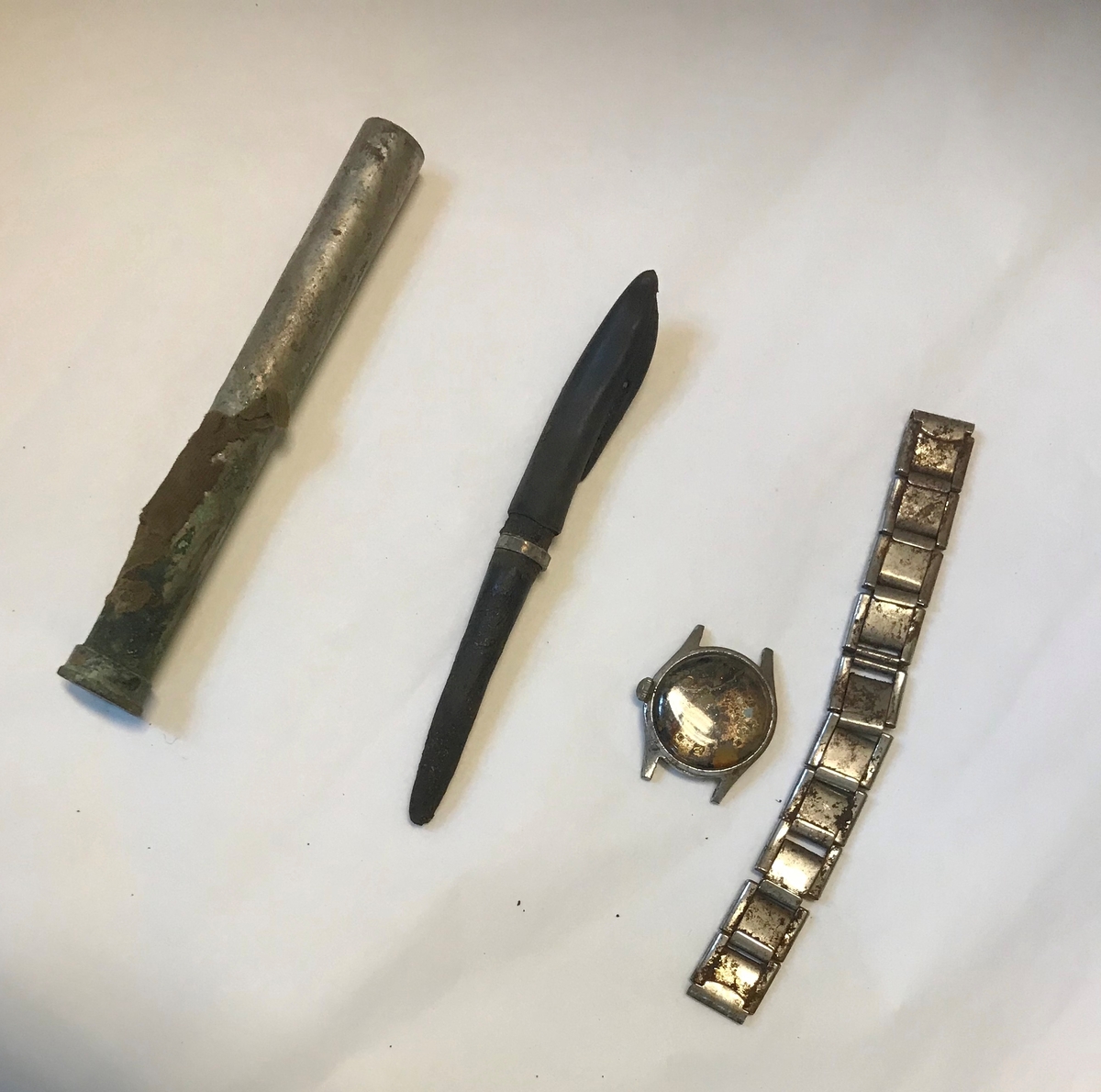 Rifle, et par gummistøvler, arbåndsur, tekstilrester, lommelykt, insulinsprøyte i metallrør, penn, kniv, slire, 13 mynter, en plastbit, hanske, 2 små glassflasker og en stor glassflaske.