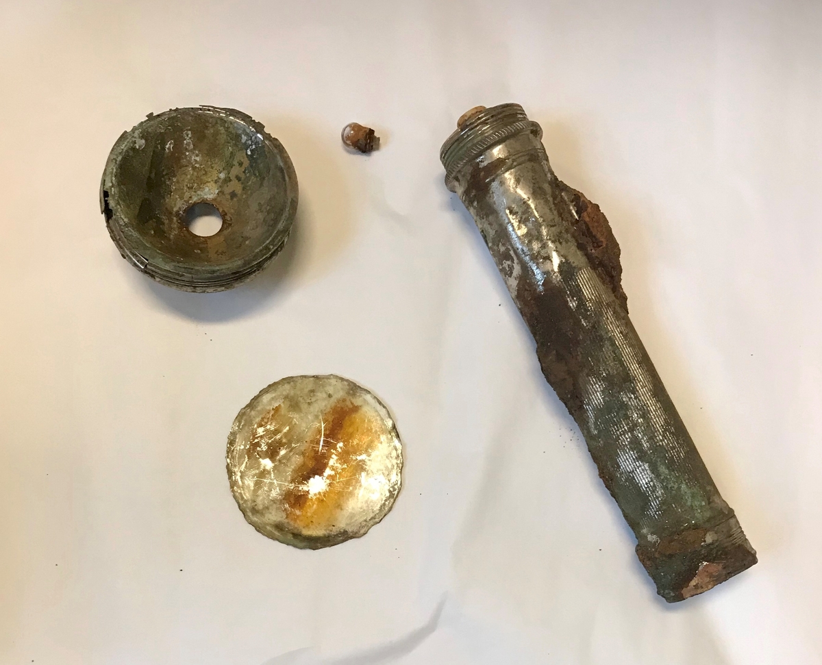 Rifle, et par gummistøvler, arbåndsur, tekstilrester, lommelykt, insulinsprøyte i metallrør, penn, kniv, slire, 13 mynter, en plastbit, hanske, 2 små glassflasker og en stor glassflaske.