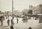 Stortorget i Växjö, en marknadsdag ca. 1900. Till höger ser man stadshotellet/stadshuset. I bakgrunden syns husen längs Kronobergsgatan (kvarteret Lejonet) och domkyrkans torn.